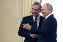 Russia's President Vladimir Putin (R) shakes hands with China's Foreign Minister Wang Yi, in Saint Petersburg, on September 20, 2023 / Photo: AFP