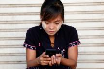 A woman using her smartphone in Pyinmana city near Nay Pyi Taw, Myanmar, November 10, 2014. Photo: Rungroj Yongrit/EPA
