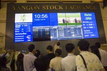 People monitor stock prices and the index displayed on a large video screen at the Yangon Stock Exchange in Yangon. Photo: Ye Aung Thu/AFP