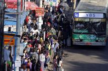People try to get onto a bus during rush hour in Yangon, Myanmar. Photo: Nyein Chan Naing/EPA
